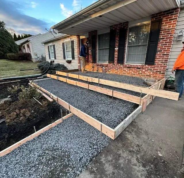 A man is standing in front of a house with a ramp being built.