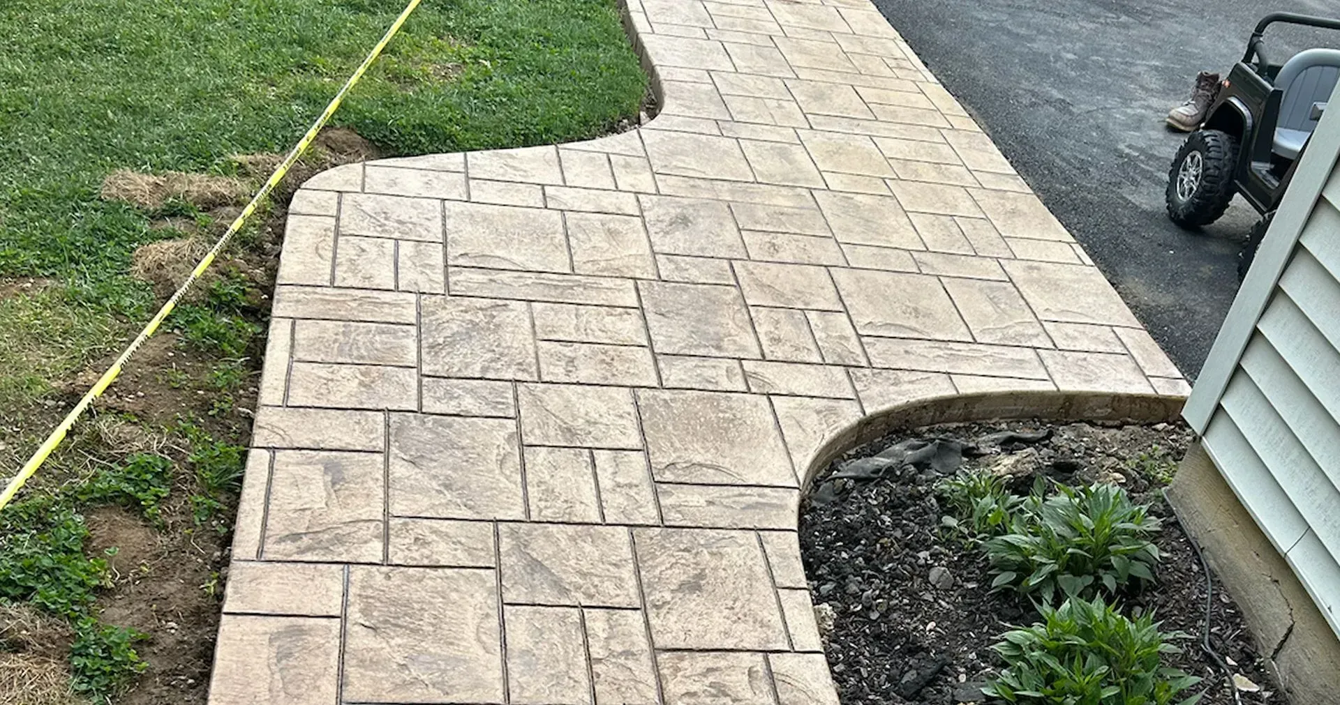 A concrete walkway is being built next to a house.