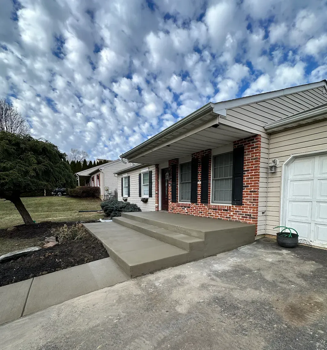A house with a garage and a porch on a cloudy day.