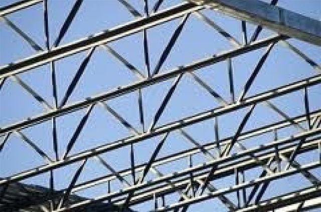 A close up of a metal structure with a blue sky in the background.
