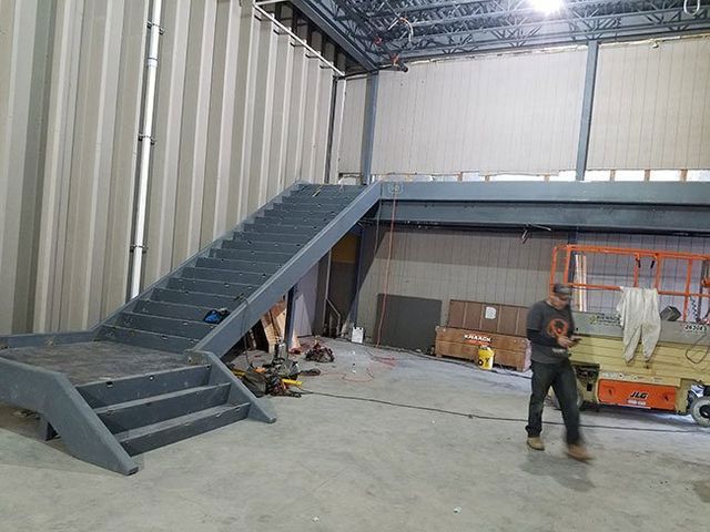 A man is standing next to a set of stairs in a building