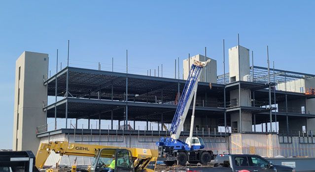 A large building under construction with a truck parked in front of it.