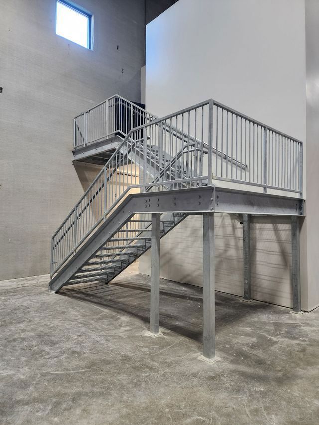 A metal staircase with a railing in an empty building.