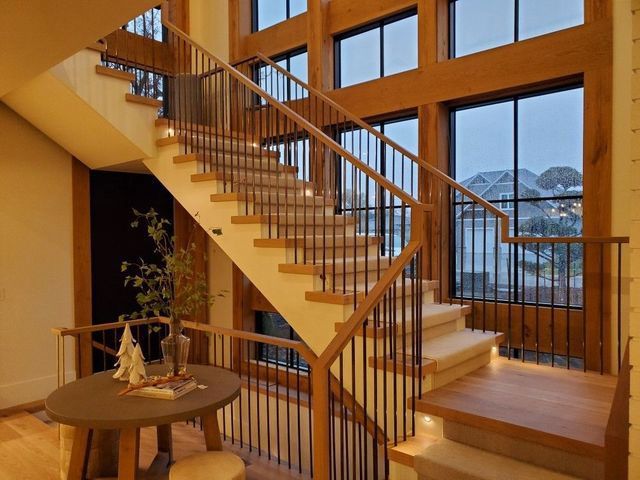 A wooden staircase with a metal railing in a house