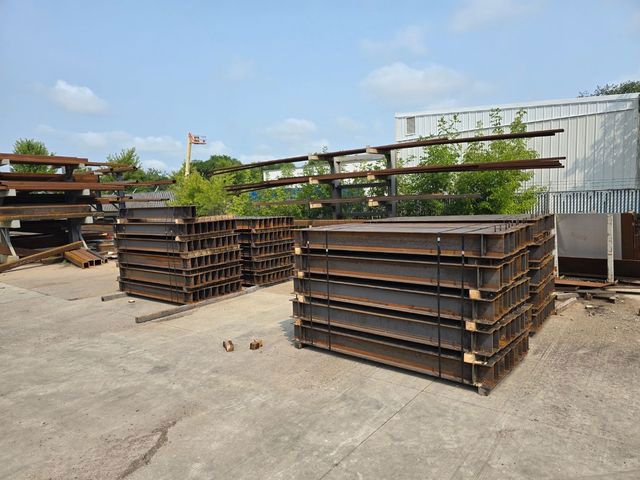 A bunch of metal boxes are stacked on top of each other in a yard.