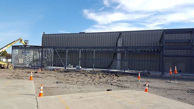 A large building is being built in a dirt field.