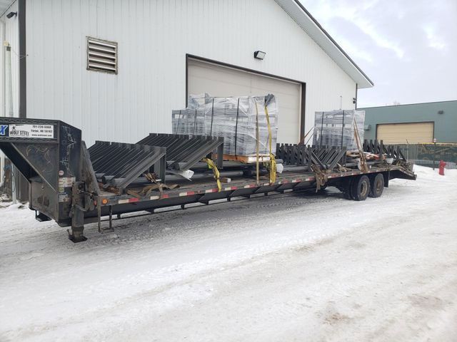 A trailer is parked in front of a building in the snow.