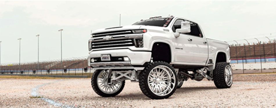 A white truck with beautiful tires and wheels