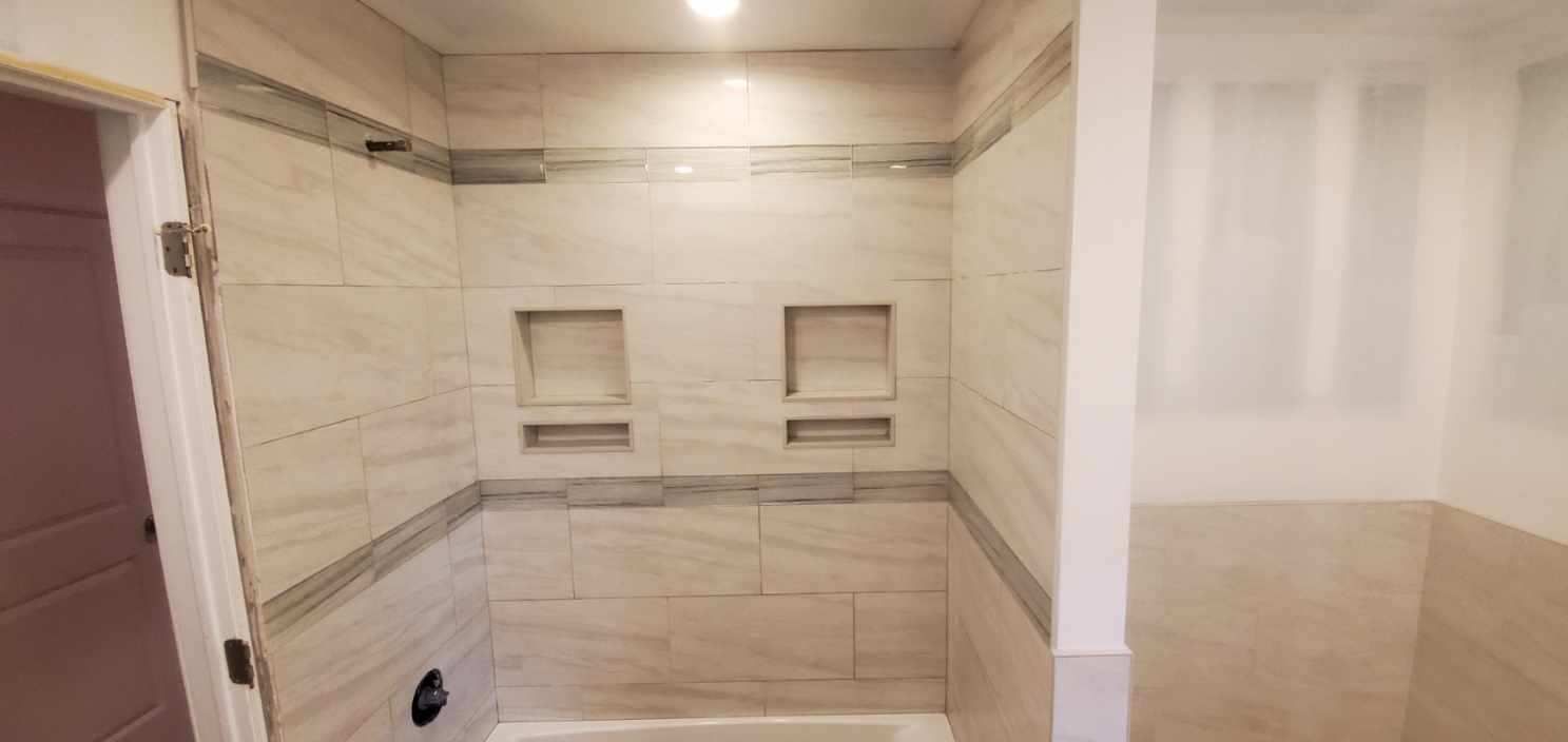A bathroom with a walk in shower and a tub.