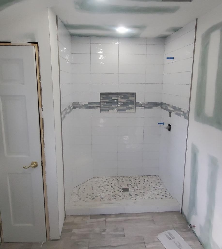 A bathroom with a walk in shower and a door.