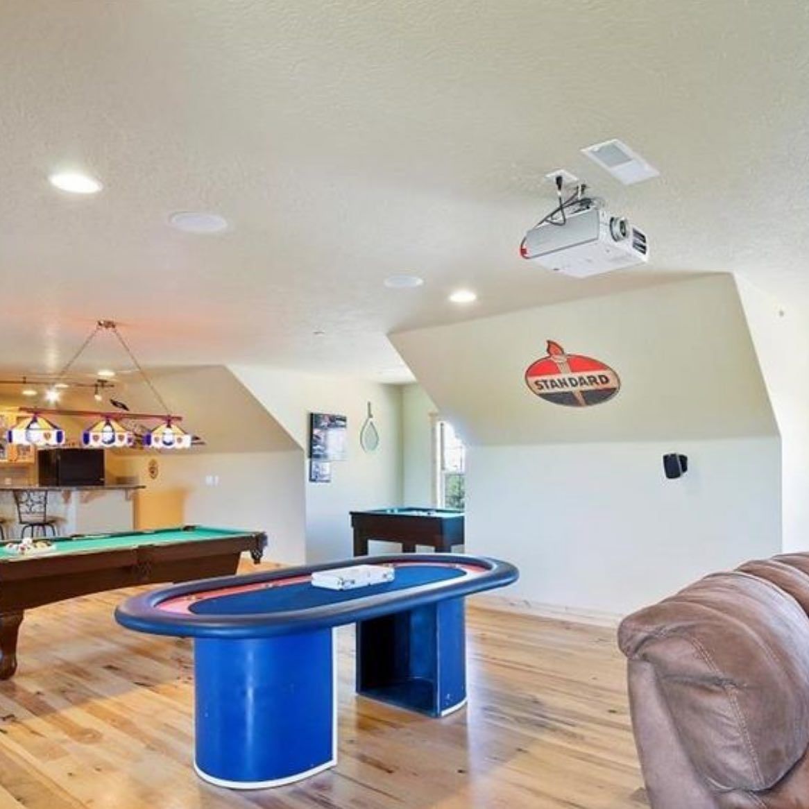 A living room with a pool table and a poker table