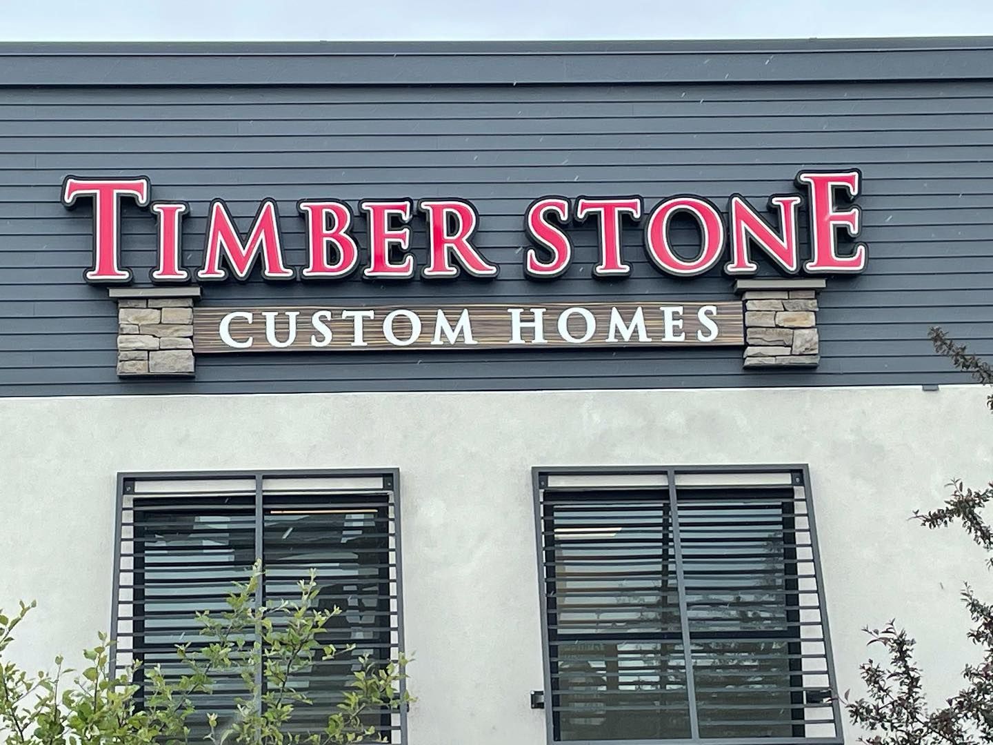 A building with a sign that says timber stone custom homes