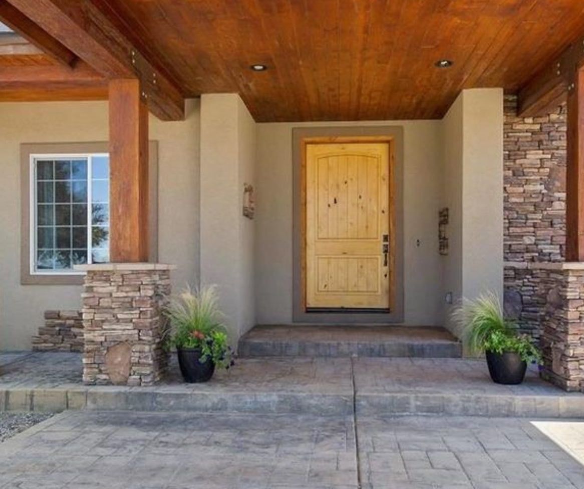 The front door of a house with a wooden ceiling