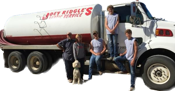 People and dog standing by a tank truck with 