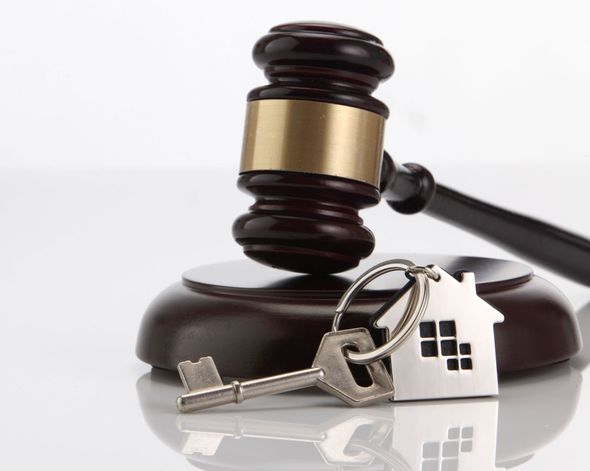 Gavel on wooden block with house key; concept of a home sale or foreclosure.