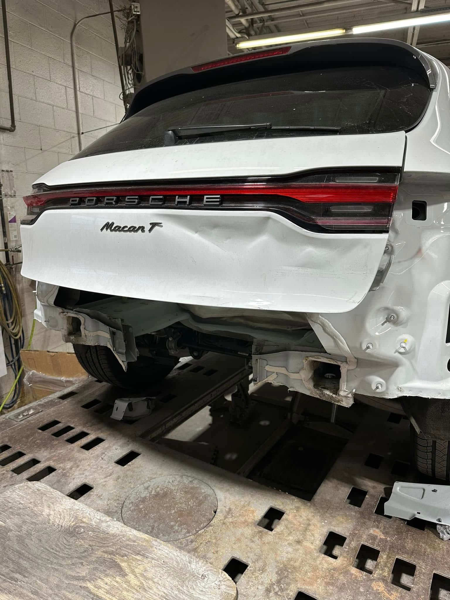 A white porsche macan t is being repaired in a garage.