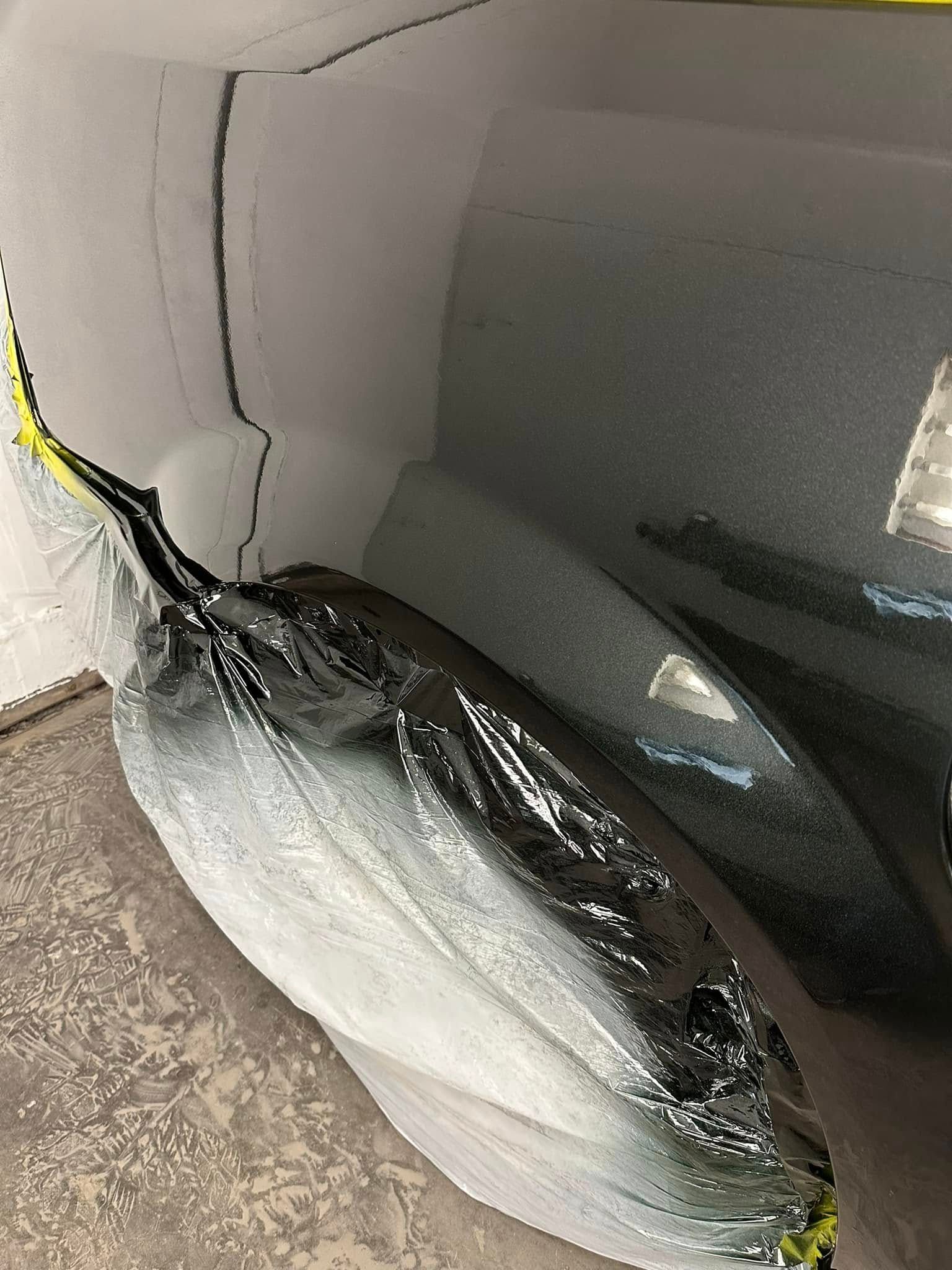 A large fish is wrapped in plastic and sitting on a table.