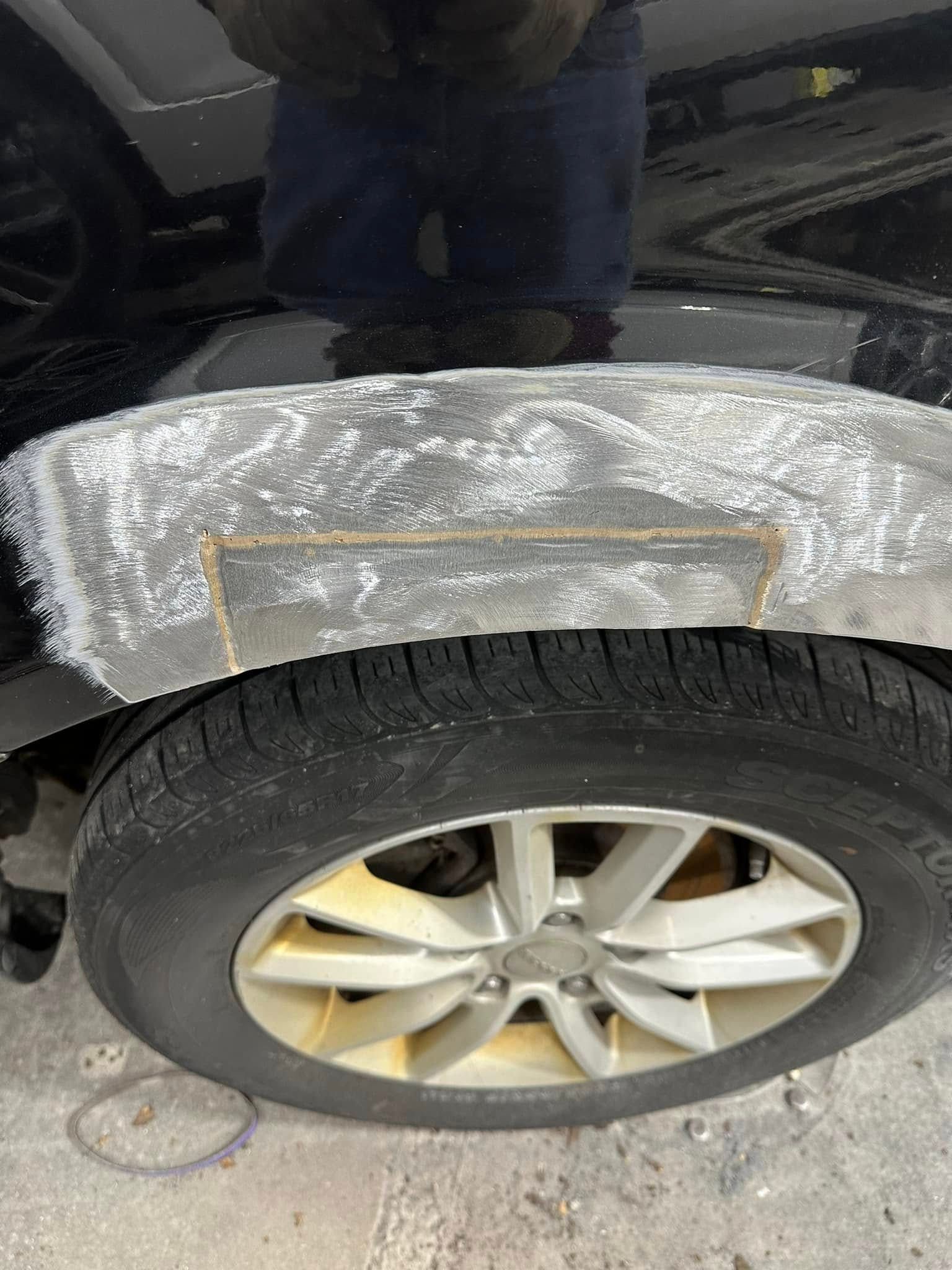 A close up of a car fender with a hole in it.