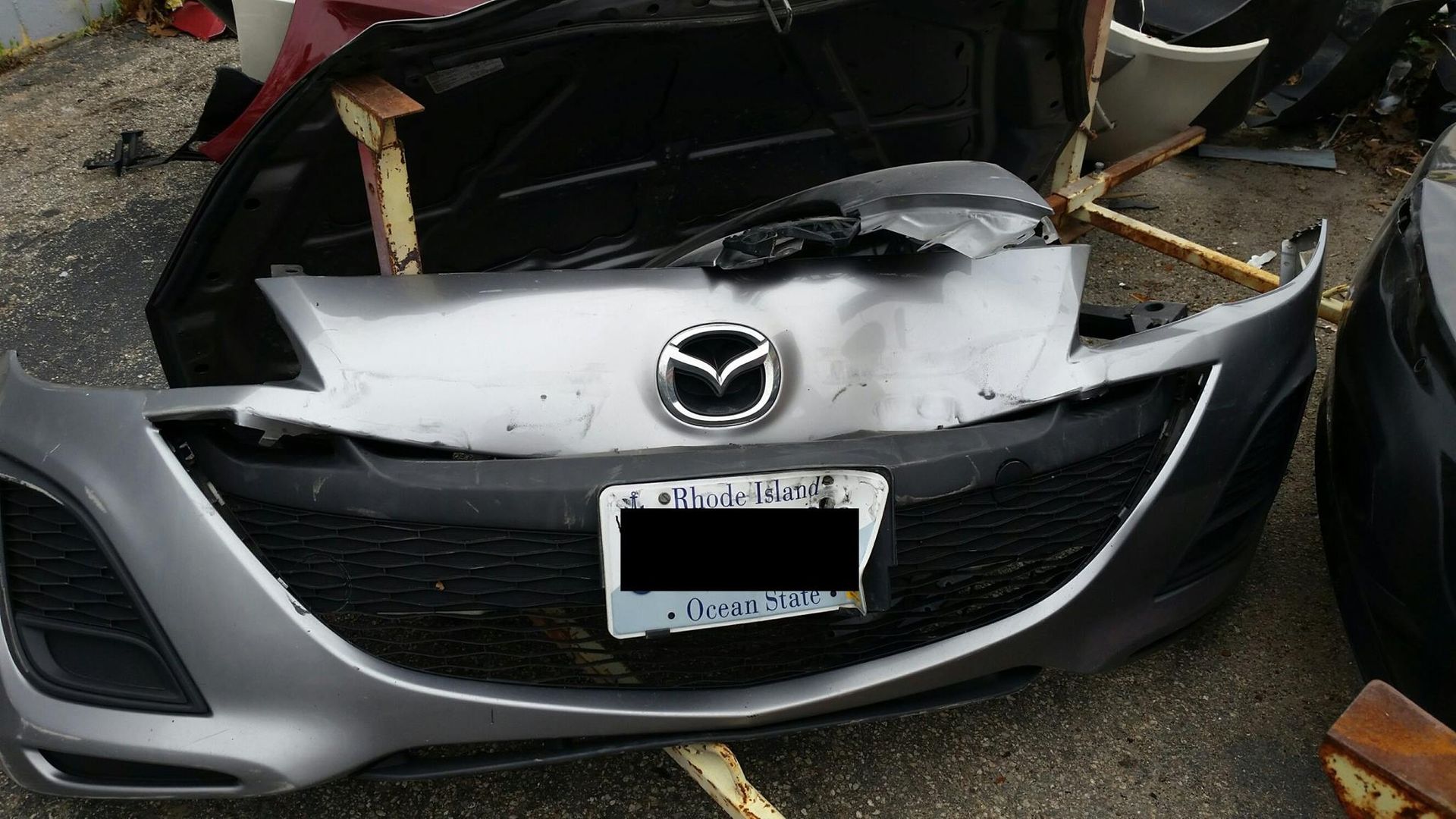 The front bumper of a mazda car is missing