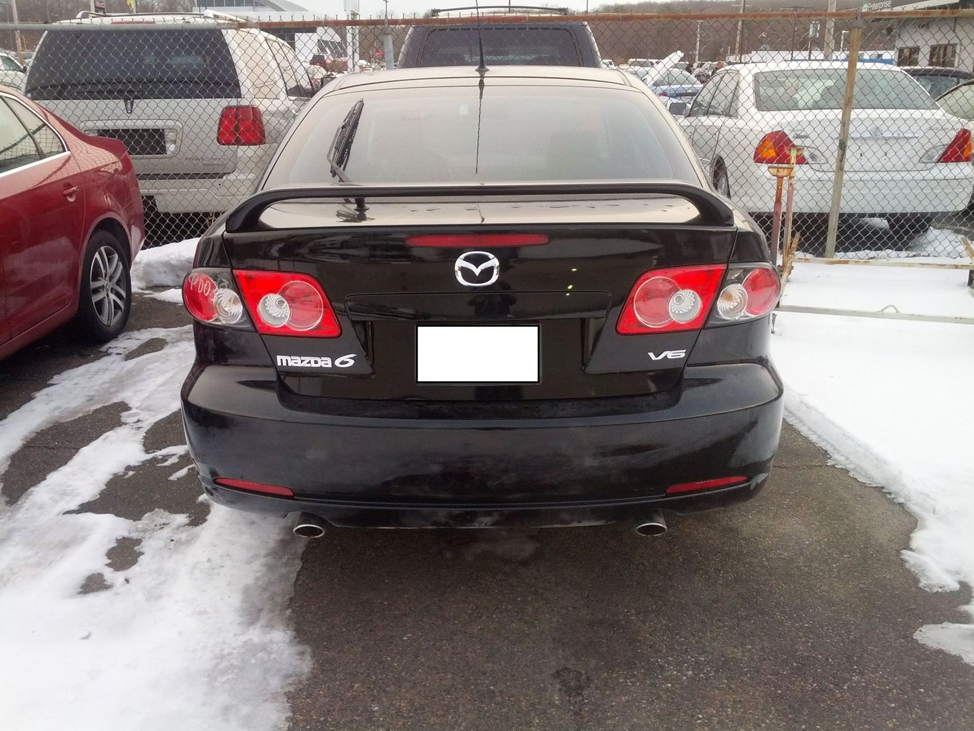 A black mazda 6 is parked in the snow