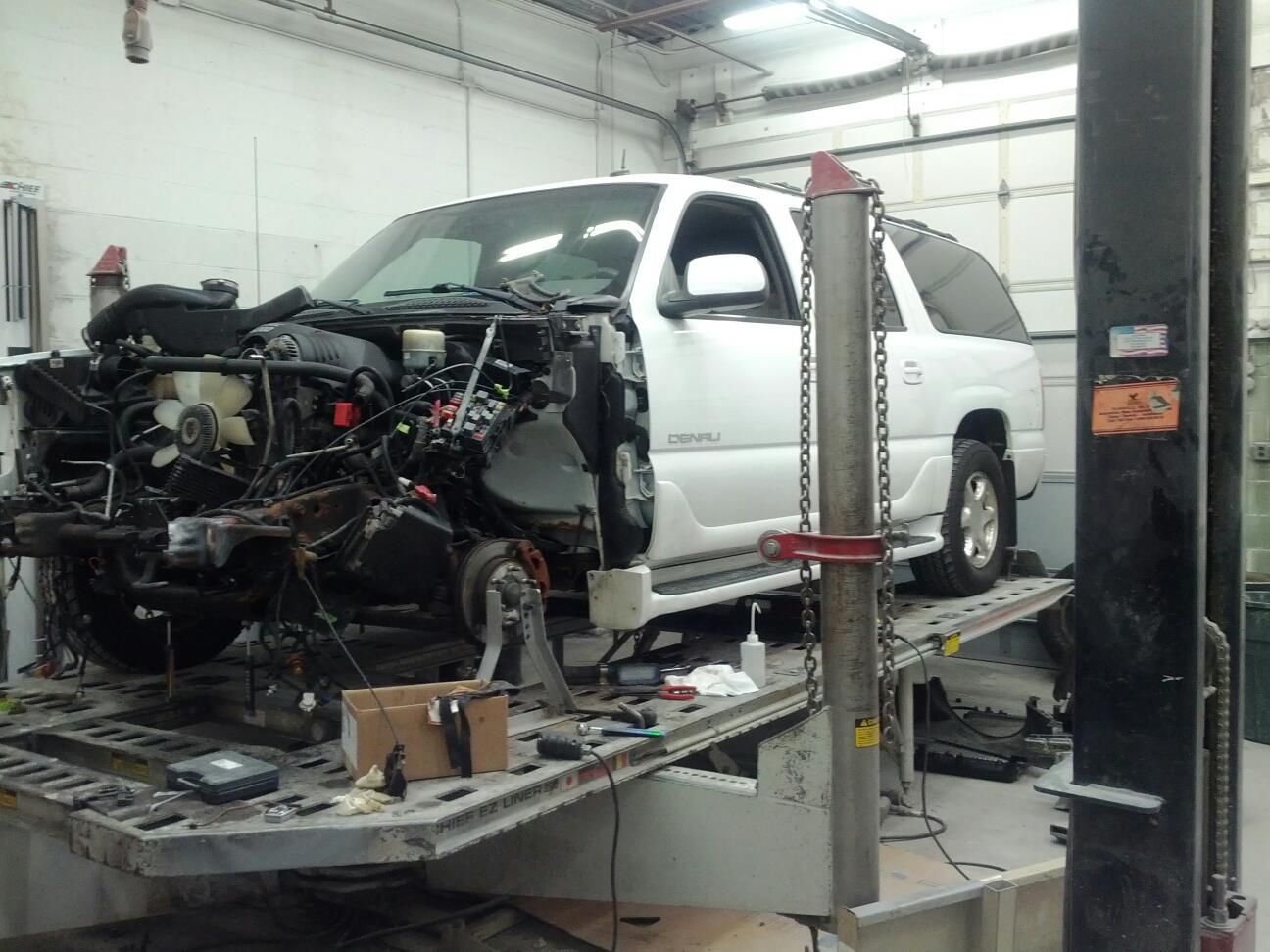 A white suv is being worked on in a garage