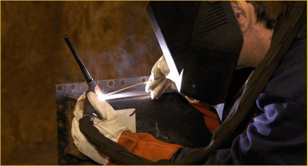 Man welding metal plate
