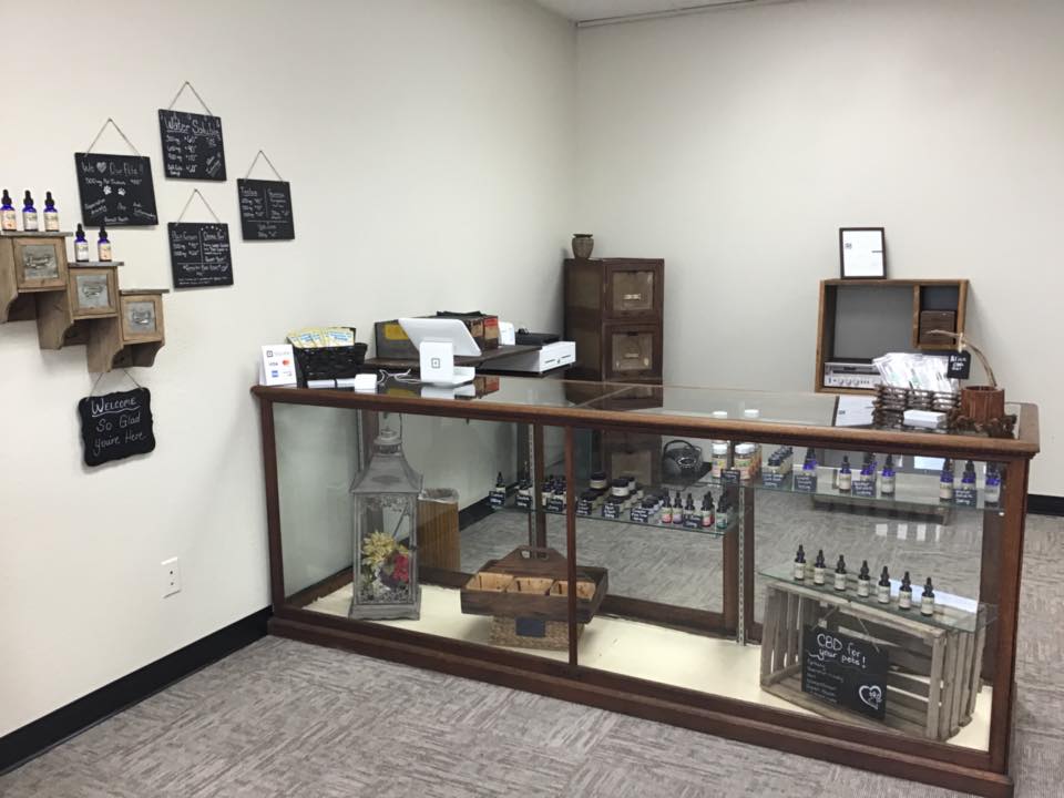 Inside a shop with a glass display case. Various products and decor. Shop is lit with overhead lights.