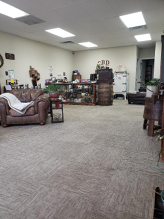 Interior shot of a CBD shop with a brown leather chair, display case, and barrel-shaped counter.