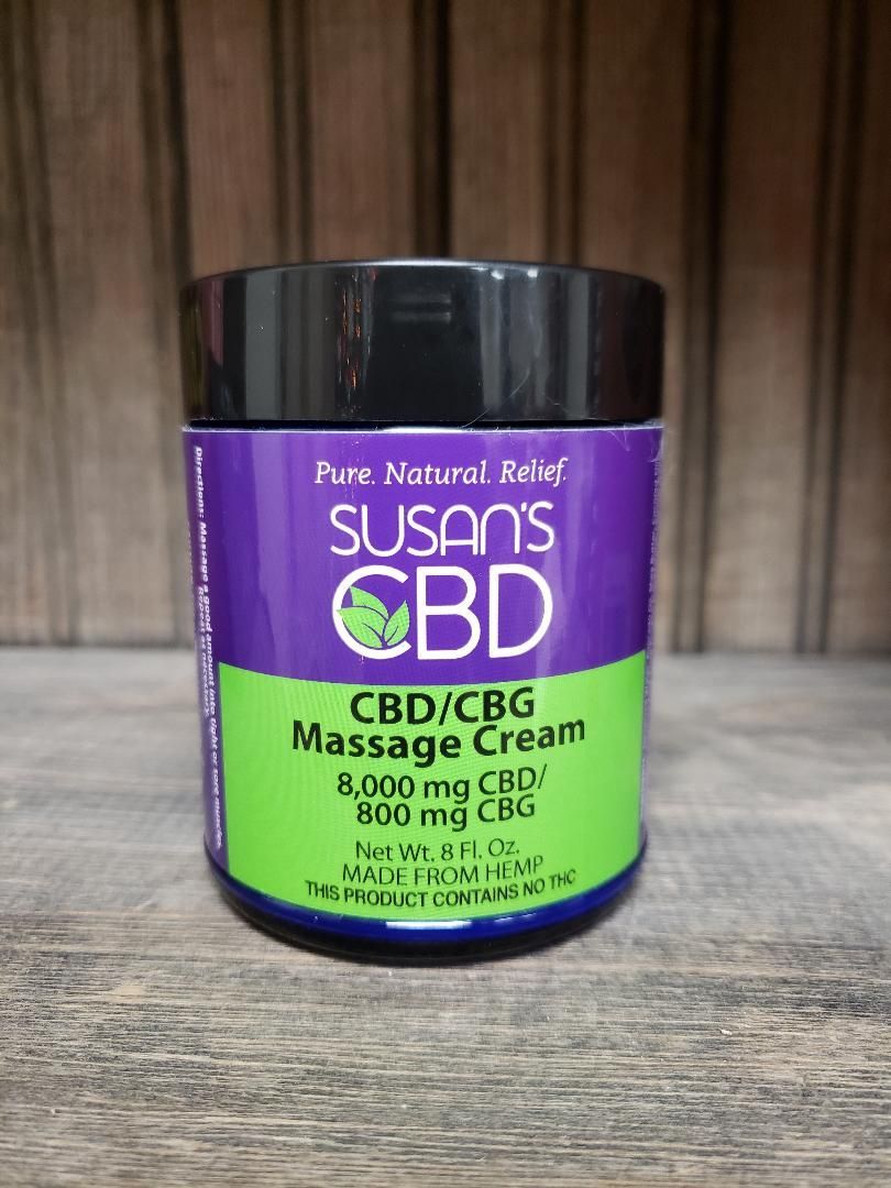 Susan's CBD massage cream jar with purple and green label, on a wooden shelf.