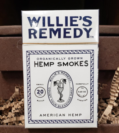 Box of Willie's Remedy hemp smokes, white packaging with blue text and design, sitting in a cardboard container.