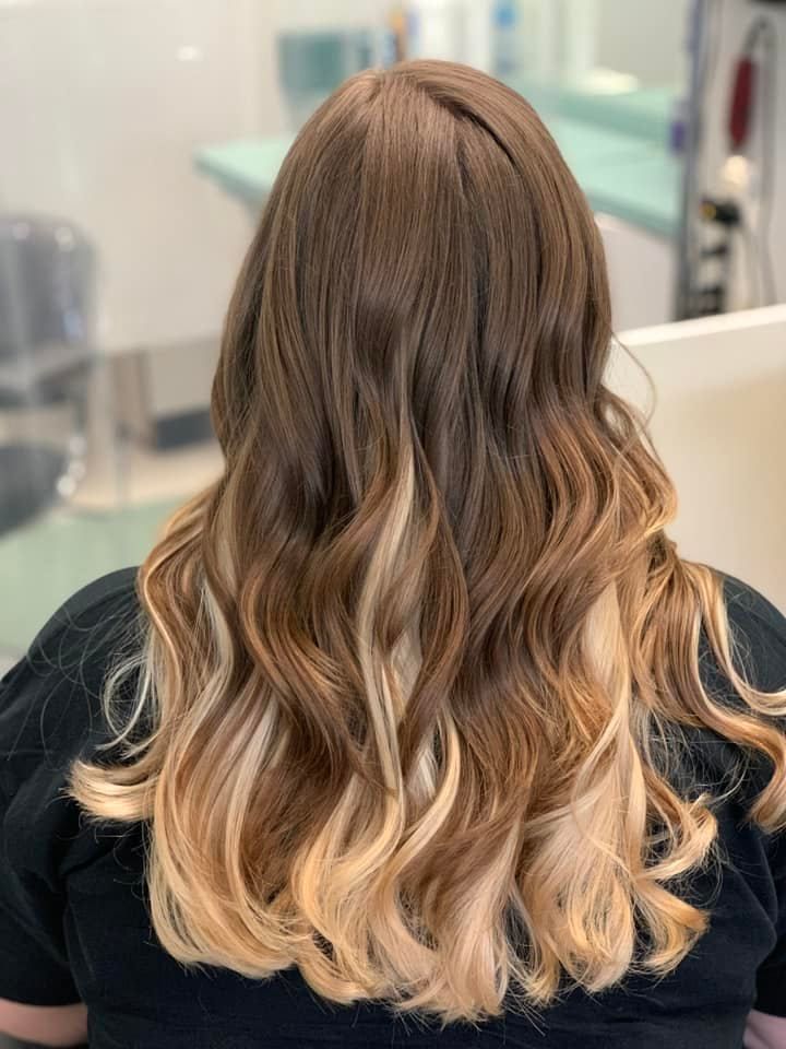 Woman with brown hair fading to blonde waves.