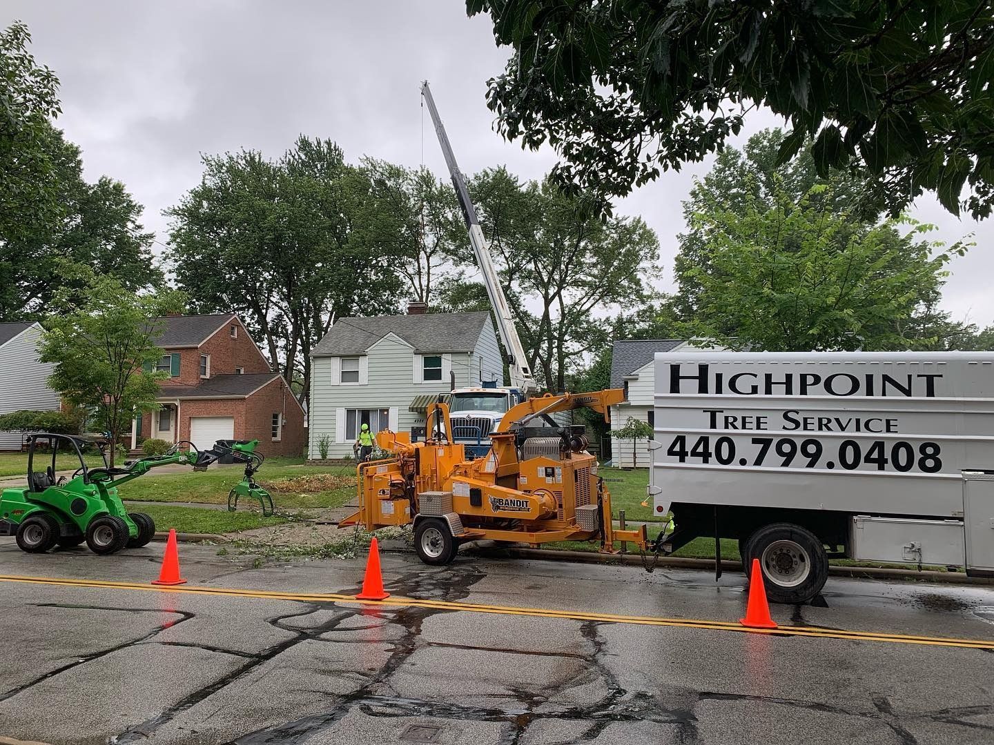 Highpoint Tree Service equipment, including a wood chipper and truck, parked on a residential street.