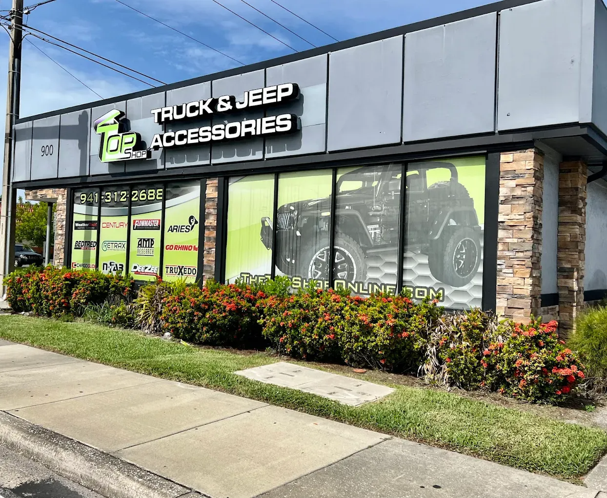 Exterior of a truck and Jeep accessories store with a large window display of a Jeep and accessories.