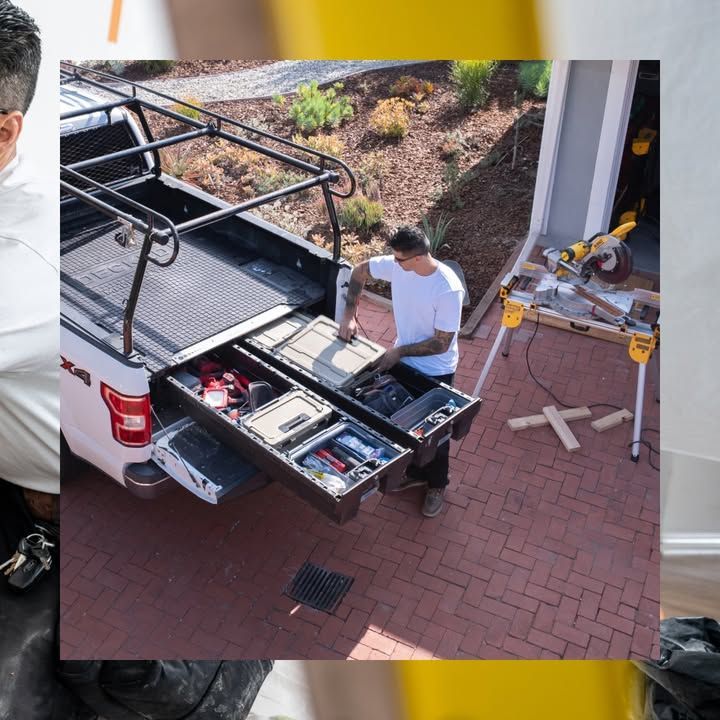 Man accessing tools from truck bed drawers; driveway setting.