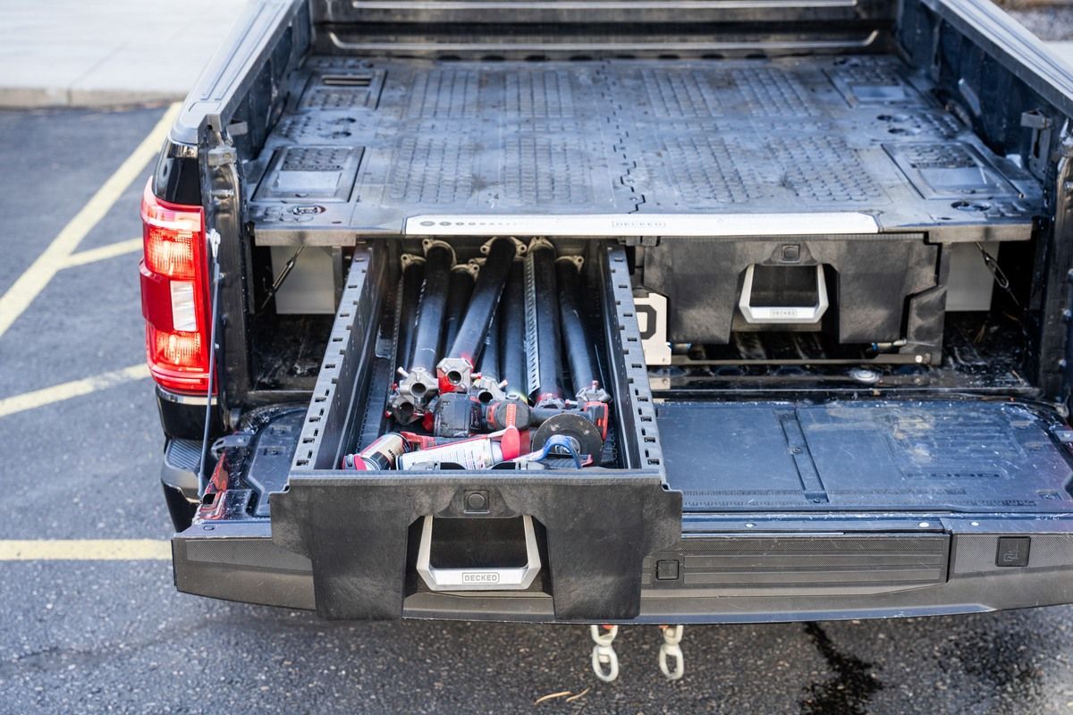 Pickup truck bed with a drawer system holding tools, open and partially extended.