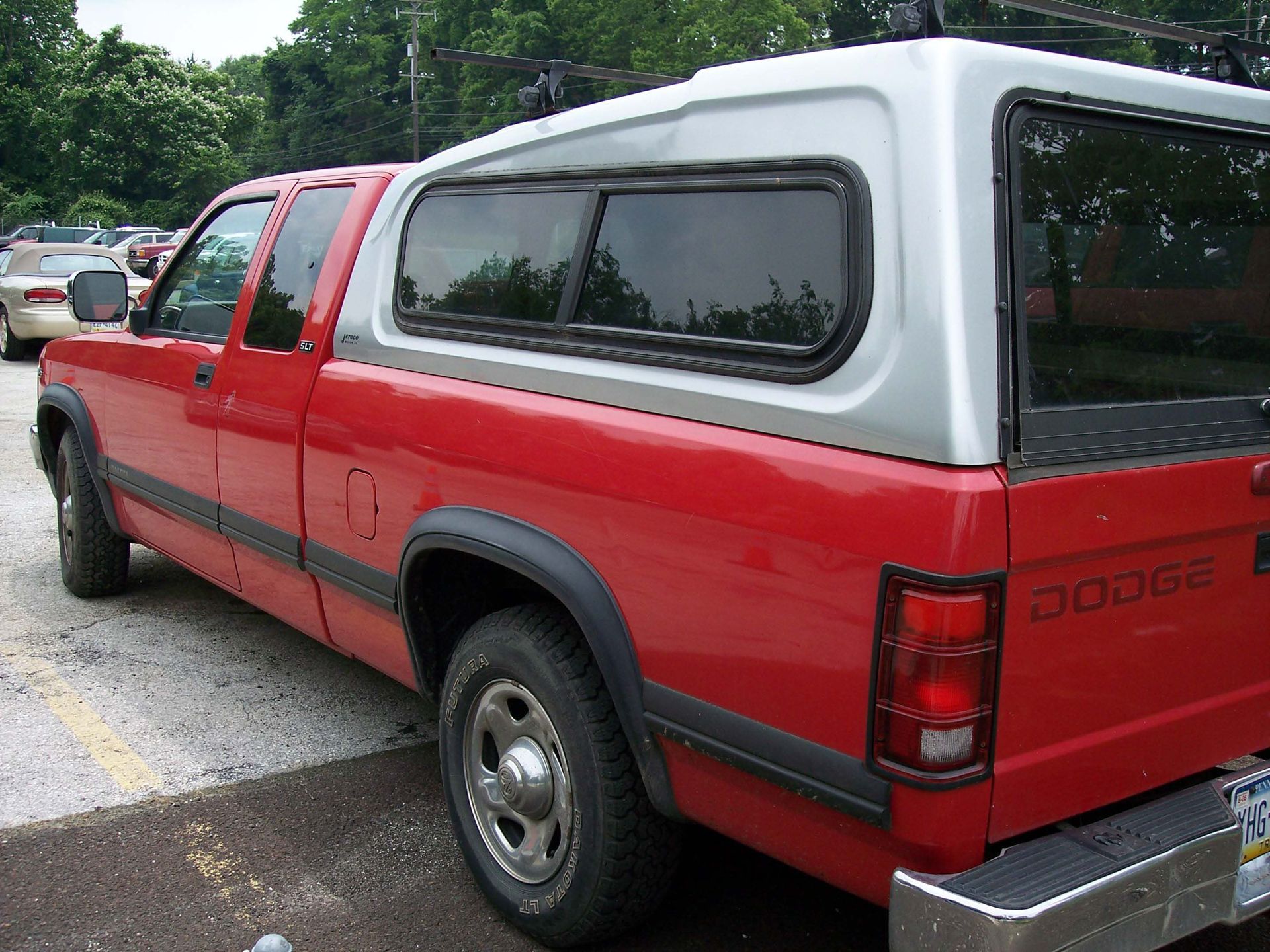 Red Dodge pickup truck with a silver camper shell.