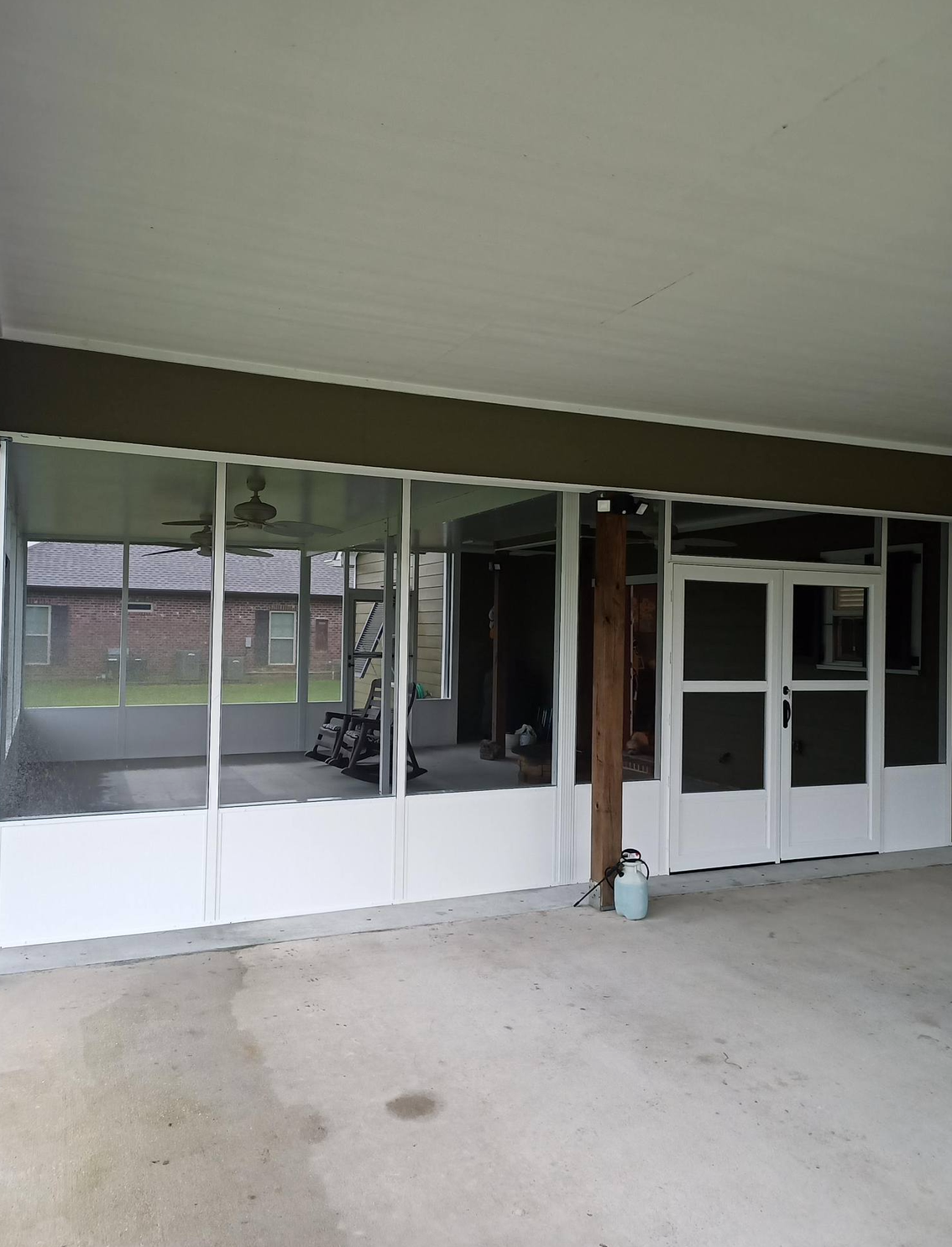 A screened in porch with a lot of windows and doors.