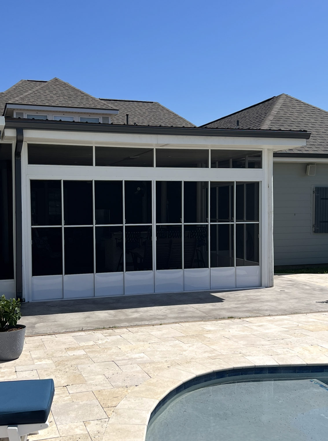 A house with a swimming pool in front of it.