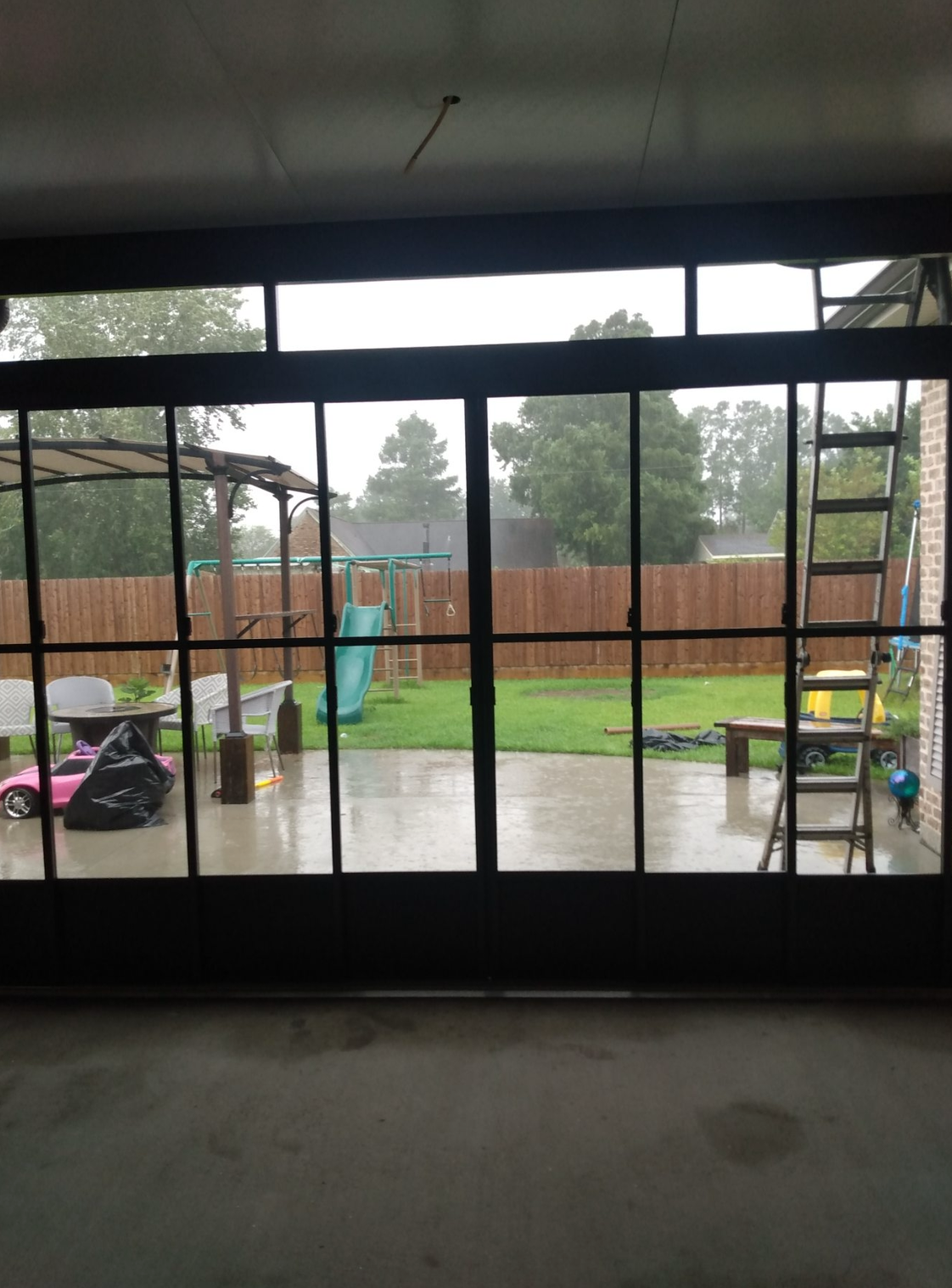 A view of a backyard through a sliding glass door.