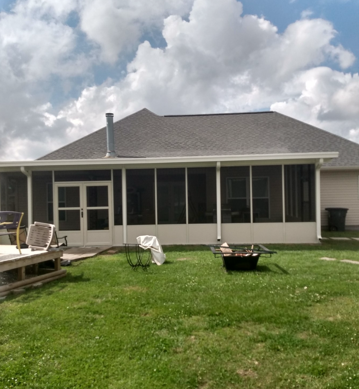 A house with a screened in porch in the backyard.