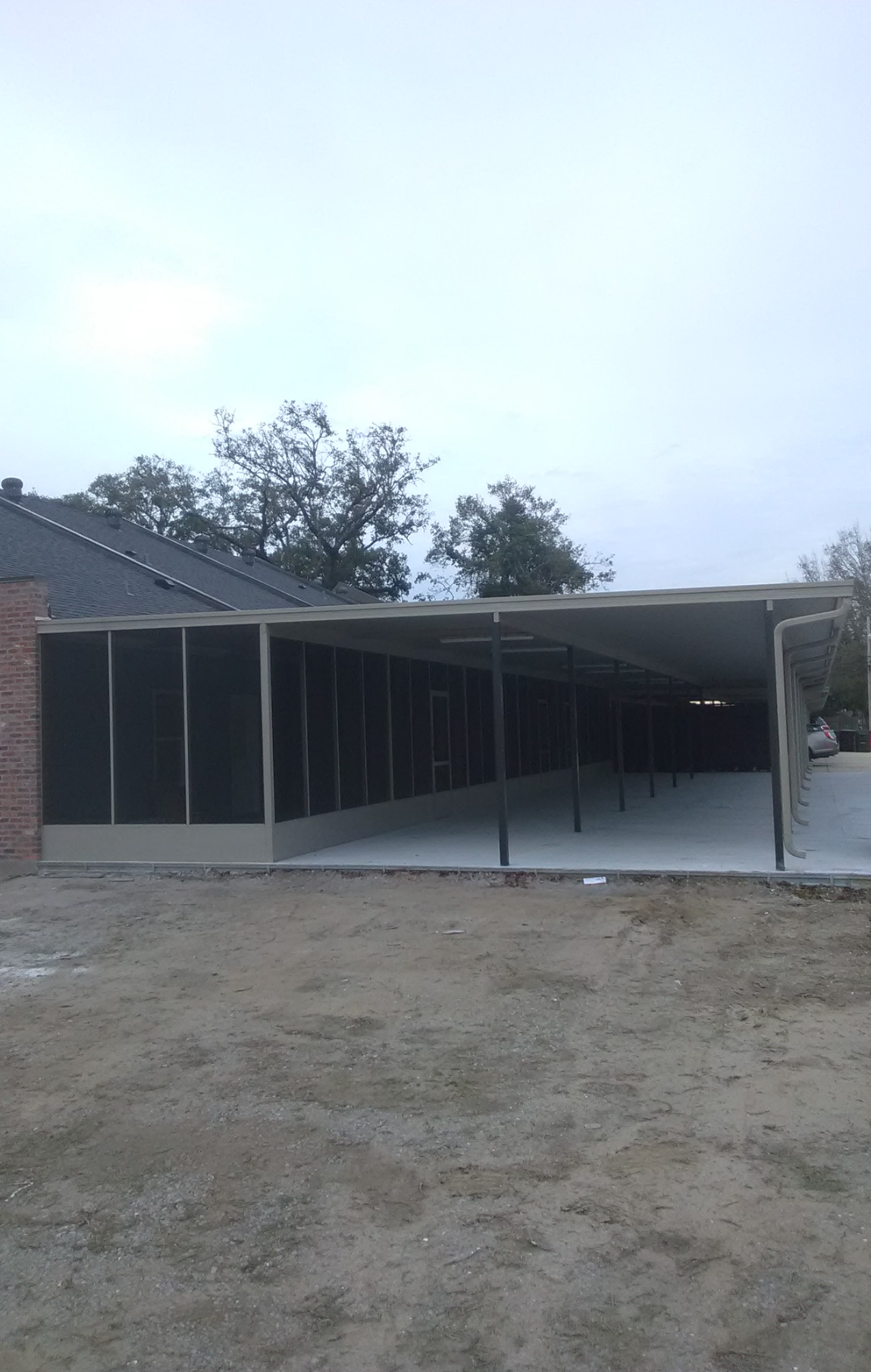 A carport is being built in the backyard of a house.