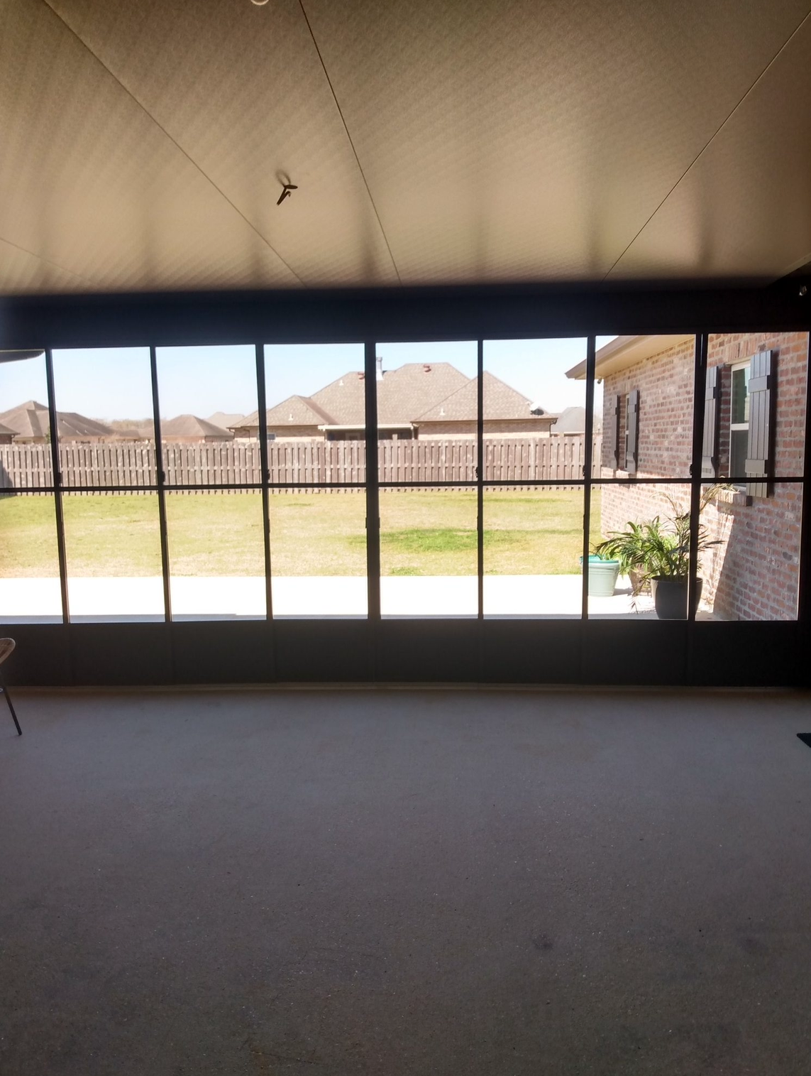A room with a lot of windows and a view of a house.