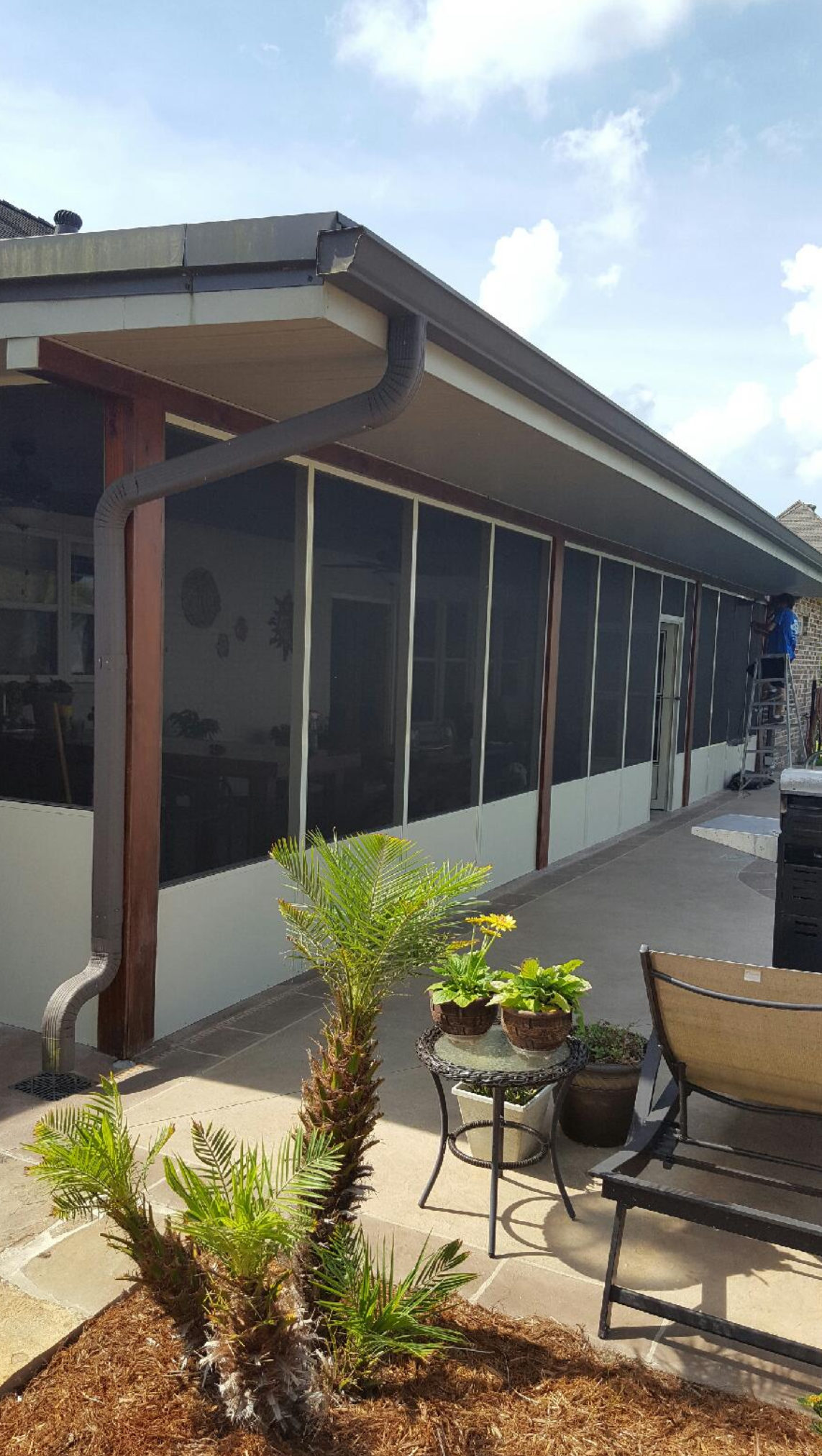 A house with a screened in porch and patio area.