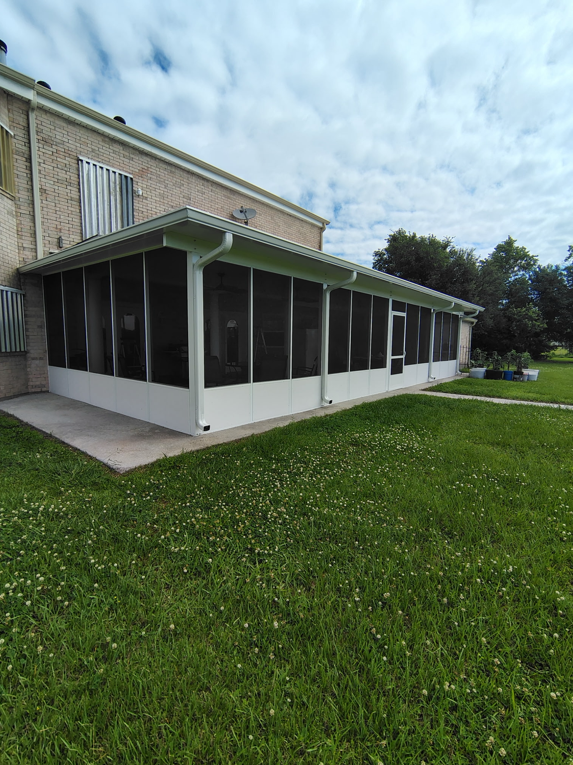 There is a screened in porch on the side of a house.