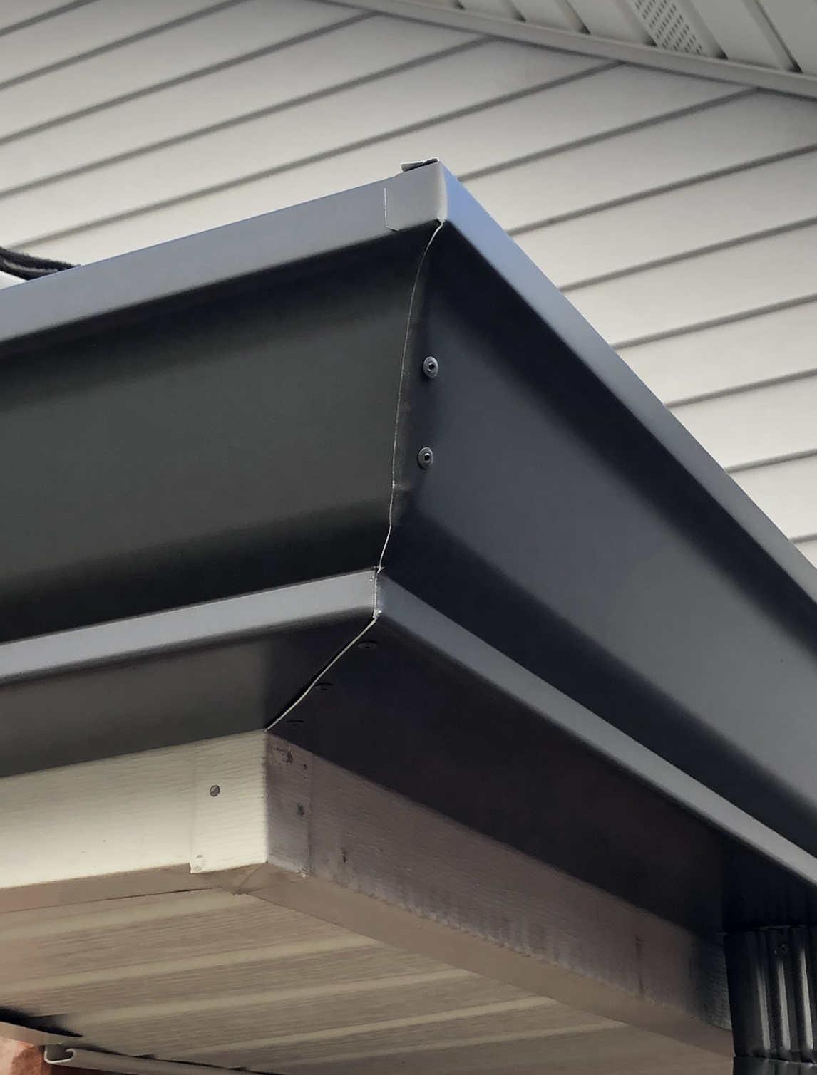 A black gutter on the side of a house.