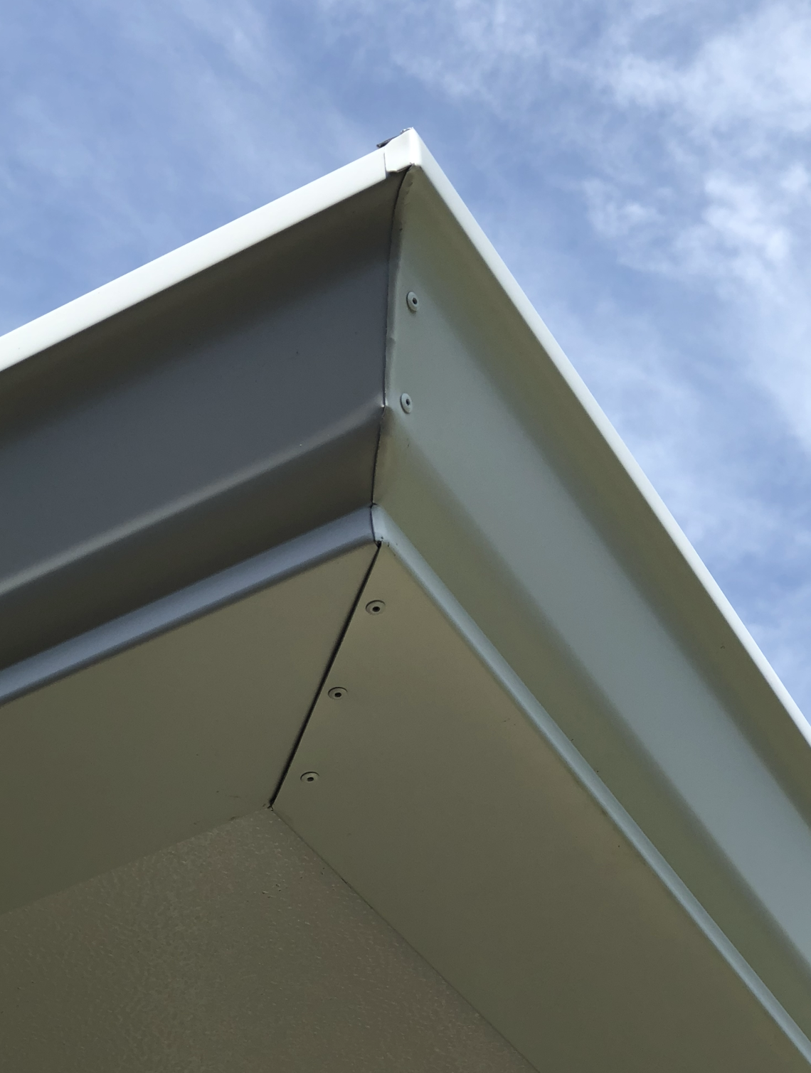 A close up of a roof with a blue sky in the background.