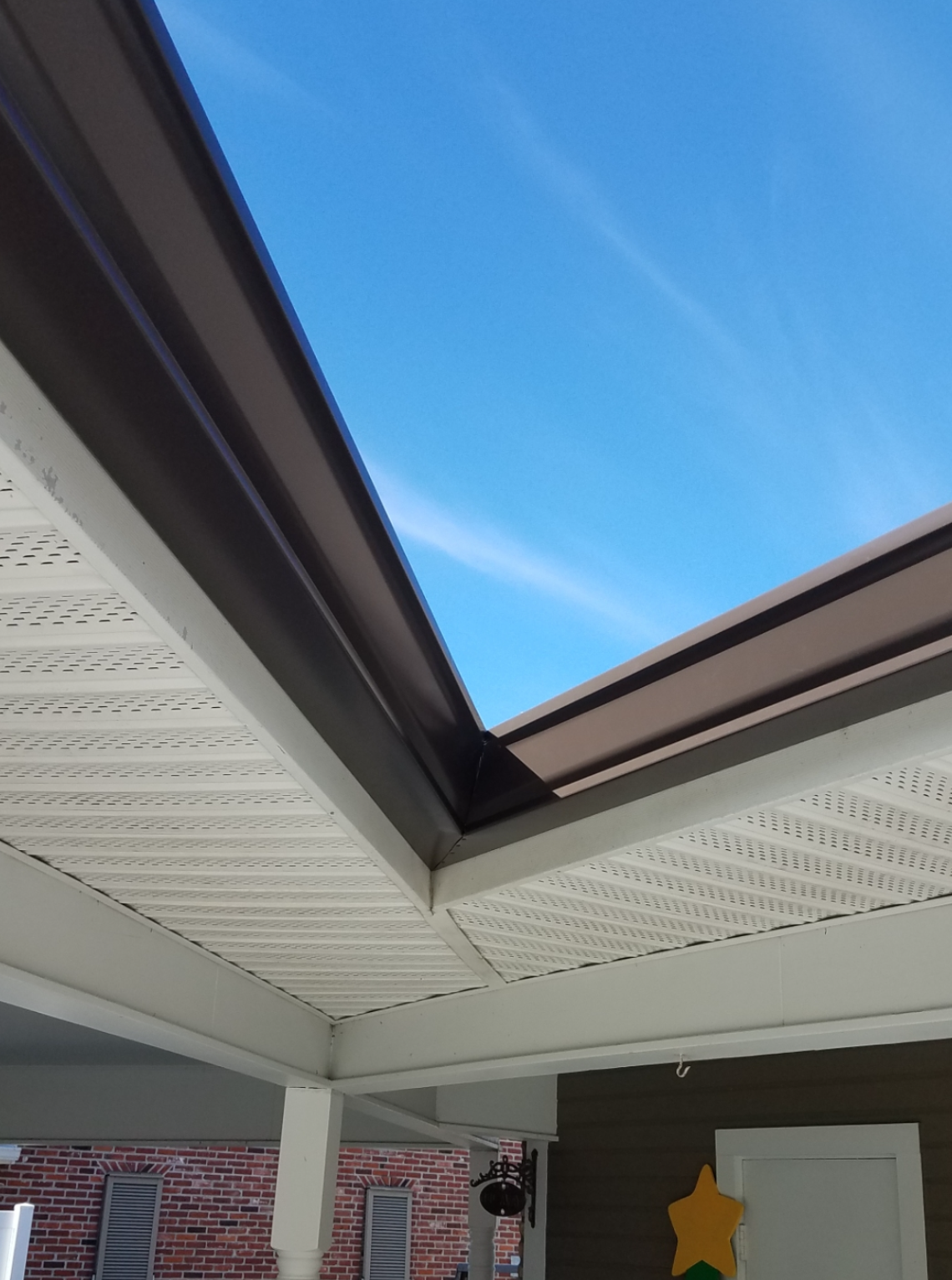 Looking up at a roof with a blue sky in the background.