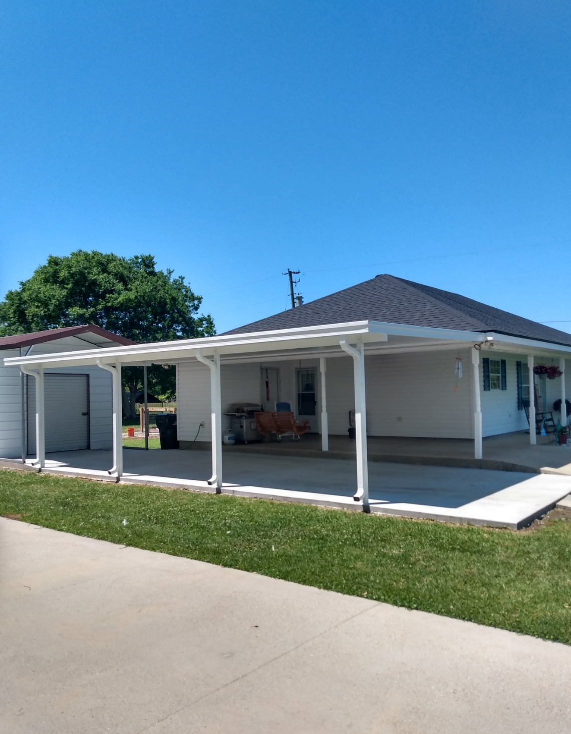 A white house with a covered driveway and a covered porch.