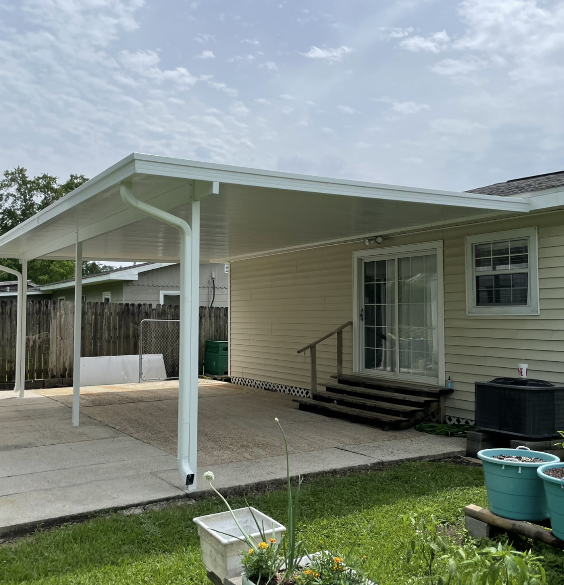 A white house with a covered patio in the backyard.