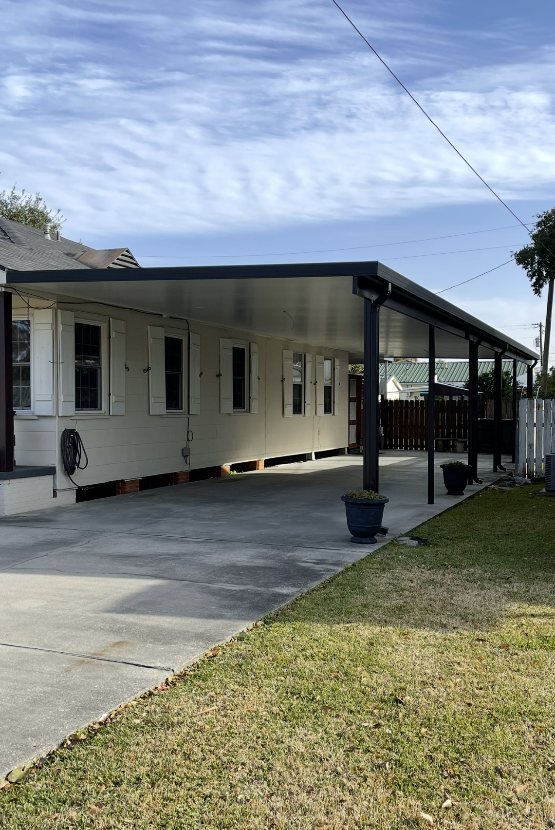 A white house with a covered driveway and a porch.